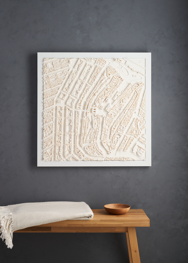 Large format cityscape of Amsterdam in a white frame hanging on a grey wall