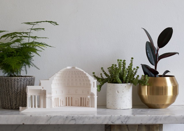 Pantheon cutaway architectural scale model on a shelf with plant pots